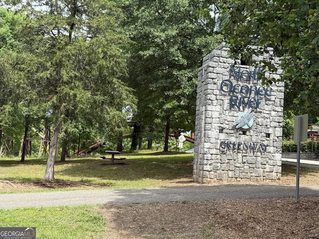 community / neighborhood sign featuring a yard