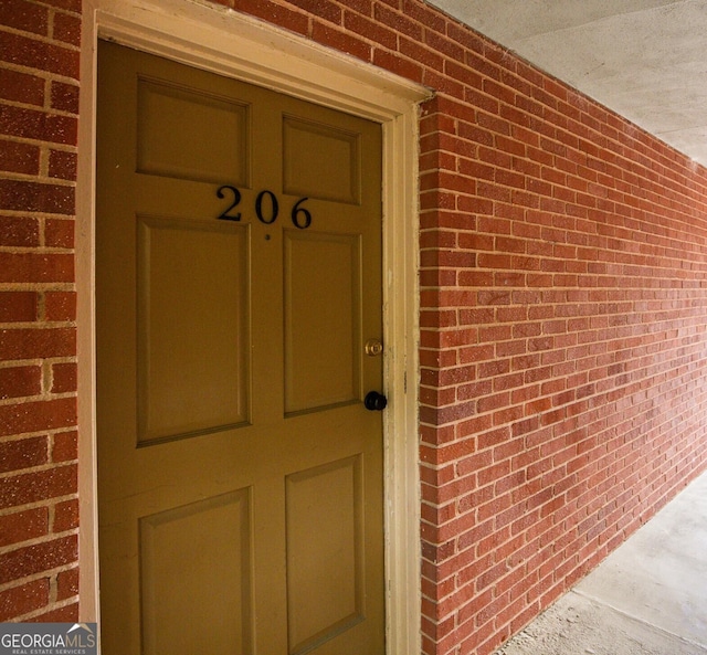 doorway to property with brick siding
