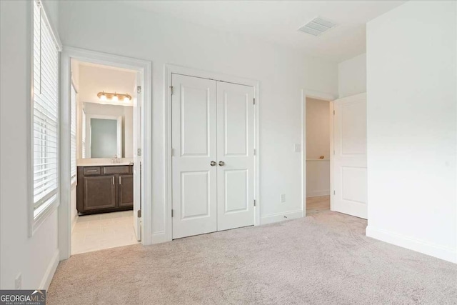 1309 Bennett Creek Ovlk, Suwanee, GA 30024 - unfurnished bedroom featuring light colored carpet, a closet, connected bathroom, and baseboards