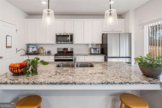 179 Leyland Xing, Dallas, GA 30132 - kitchen featuring appliances with stainless steel finishes, a sink, a breakfast bar area, white cabinets, and recessed lighting