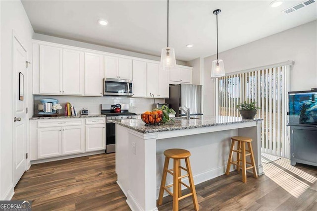 179 Leyland Xing, Dallas, GA 30132 - kitchen featuring stainless steel appliances, dark wood-style flooring, white cabinetry, a breakfast bar area, and recessed lighting