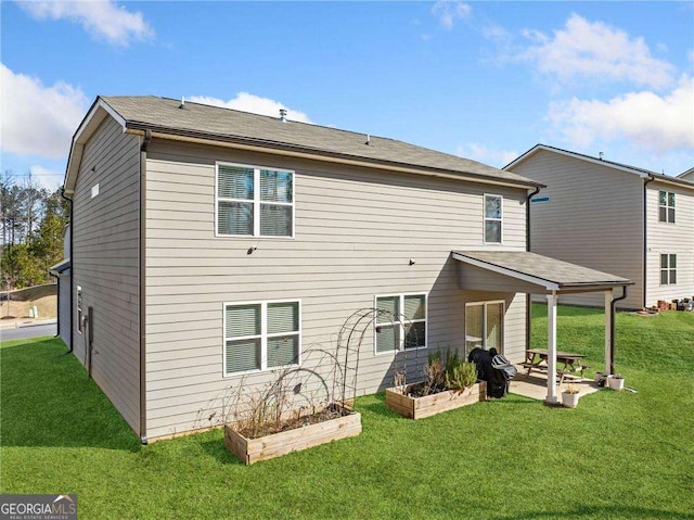 179 Leyland Xing, Dallas, GA 30132 - rear view of house featuring a lawn, a patio, and a vegetable garden