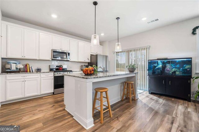 179 Leyland Xing, Dallas, GA 30132 - kitchen with stainless steel appliances, wood finished floors, an island with sink, white cabinetry, and recessed lighting