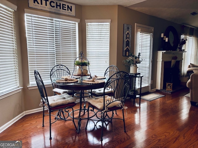 486 Village Cir, Stockbridge, GA 30281 - dining space featuring baseboards, wood finished floors, and a fireplace with raised hearth