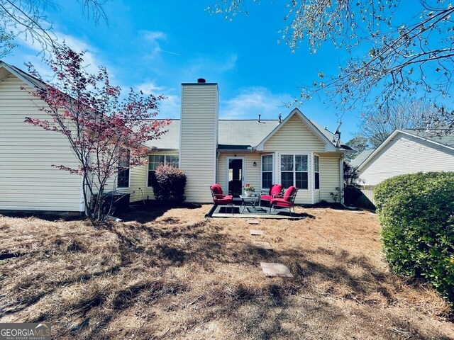 486 Village Cir, Stockbridge, GA 30281 - back of property featuring a chimney and a patio area