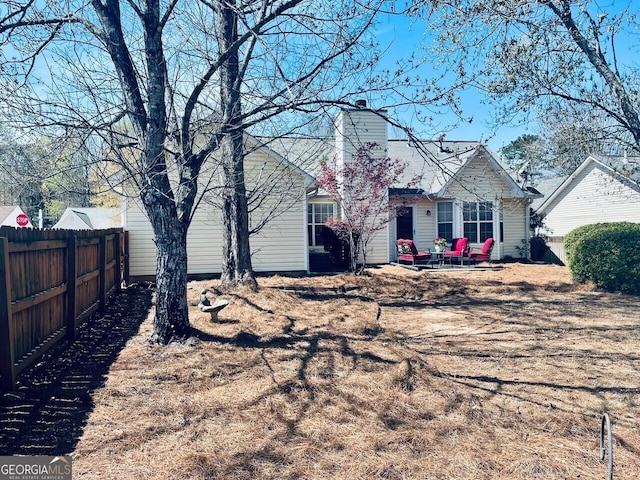 486 Village Cir, Stockbridge, GA 30281 - back of house with fence, a chimney, and a patio area