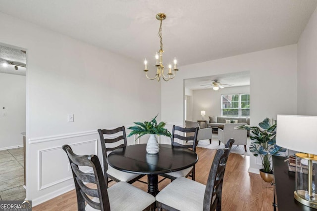 dining room featuring a chandelier, wood finished floors, and a ceiling fan