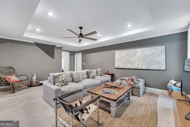 living area with a tray ceiling, light colored carpet, ceiling fan, recessed lighting, and baseboards