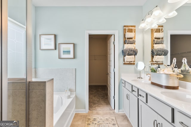 full bathroom with a bath, tile patterned flooring, double vanity, and a spacious closet