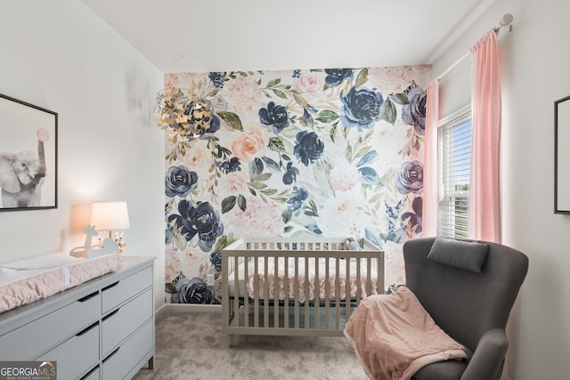 bedroom with light colored carpet, a crib, and baseboards