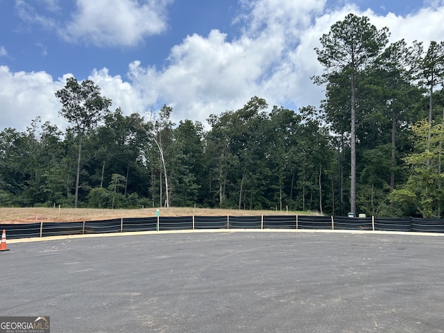 view of parking / parking lot with a forest view