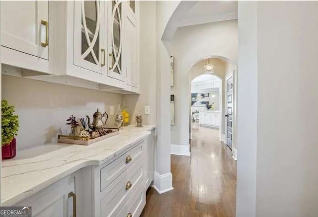2242 Shoal Creek Rd, Buford, GA 30518 - hallway featuring arched walkways, dark wood-type flooring, and baseboards