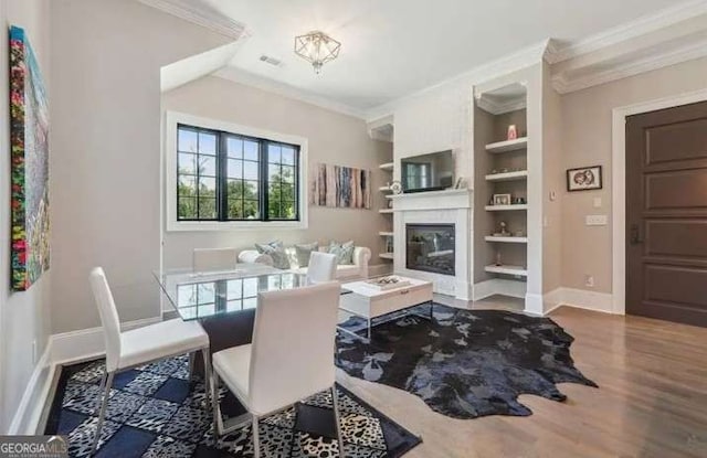 2242 Shoal Creek Rd, Buford, GA 30518 - living area featuring ornamental molding, wood finished floors, a glass covered fireplace, built in features, and baseboards