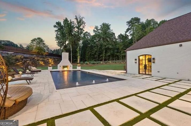 2242 Shoal Creek Rd, Buford, GA 30518 - pool at dusk with a patio, a fireplace, and an outdoor pool