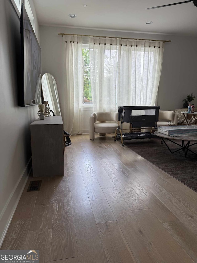 living area with hardwood / wood-style flooring and recessed lighting