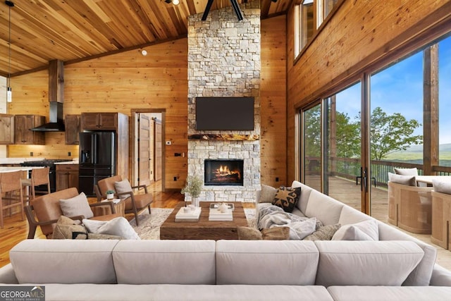 885 Tower Rd, Mineral Bluff, GA 30559 - living room featuring wooden walls, a stone fireplace, wood ceiling, wood finished floors, and high vaulted ceiling