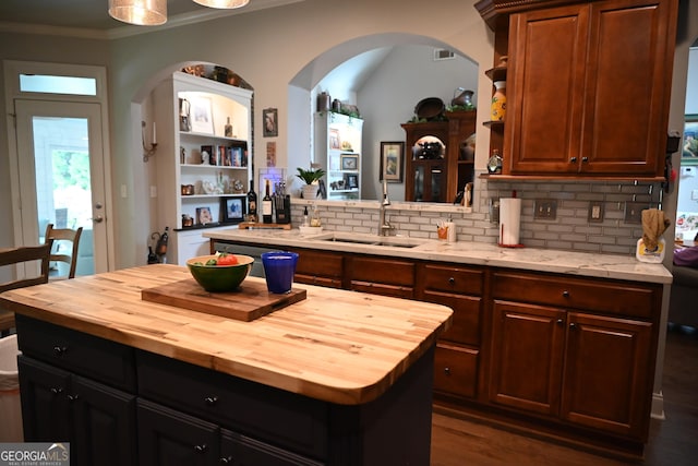 24 Douglas Dr, Jefferson, GA 30549 - kitchen with butcher block counters, arched walkways, a sink, decorative backsplash, and ornamental molding