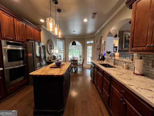 24 Douglas Dr, Jefferson, GA 30549 - kitchen with butcher block counters, appliances with stainless steel finishes, a sink, arched walkways, and ornamental molding