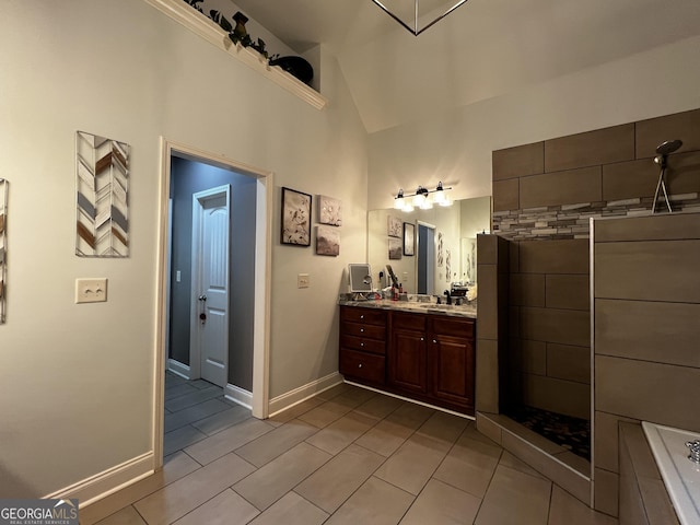 24 Douglas Dr, Jefferson, GA 30549 - full bath with tile patterned floors, a tile shower, vanity, high vaulted ceiling, and baseboards