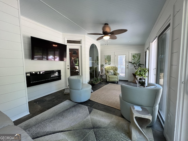 24 Douglas Dr, Jefferson, GA 30549 - living room with stone tile flooring, a ceiling fan, wood walls, and vaulted ceiling