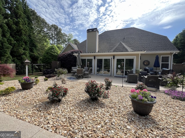 24 Douglas Dr, Jefferson, GA 30549 - rear view of house featuring a chimney, a patio, roof with shingles, and outdoor dining area