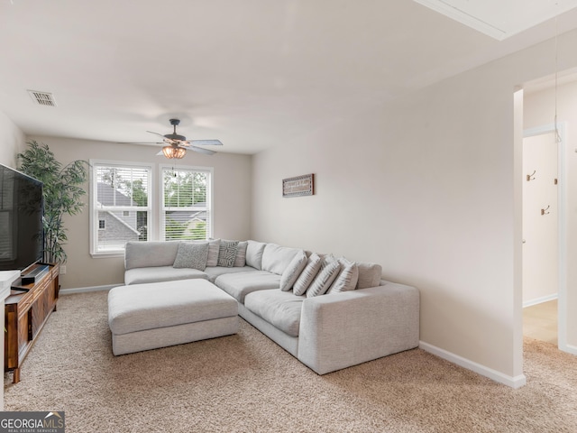 living area featuring attic access, carpet flooring, ceiling fan, and baseboards