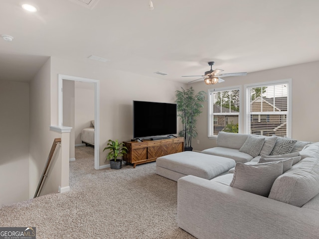 carpeted living room featuring ceiling fan and baseboards