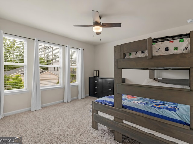 carpeted bedroom featuring baseboards and ceiling fan