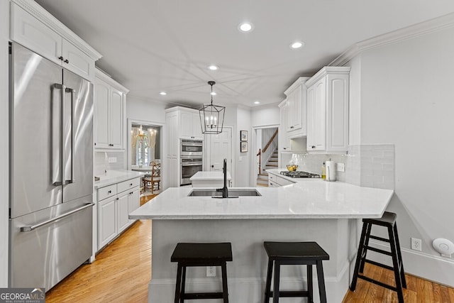 2332 Autumn Maple Dr, Braselton, GA 30517 - kitchen with appliances with stainless steel finishes, a sink, a peninsula, white cabinets, and recessed lighting