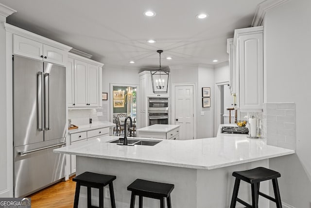 2332 Autumn Maple Dr, Braselton, GA 30517 - kitchen featuring appliances with stainless steel finishes, a sink, a peninsula, white cabinets, and tasteful backsplash