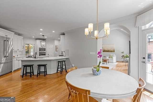 2332 Autumn Maple Dr, Braselton, GA 30517 - dining space with light wood-style flooring, recessed lighting, a chandelier, crown molding, and arched walkways