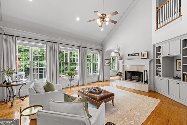 2332 Autumn Maple Dr, Braselton, GA 30517 - living area featuring ornamental molding, a ceiling fan, high vaulted ceiling, a tile fireplace, and light wood-style floors