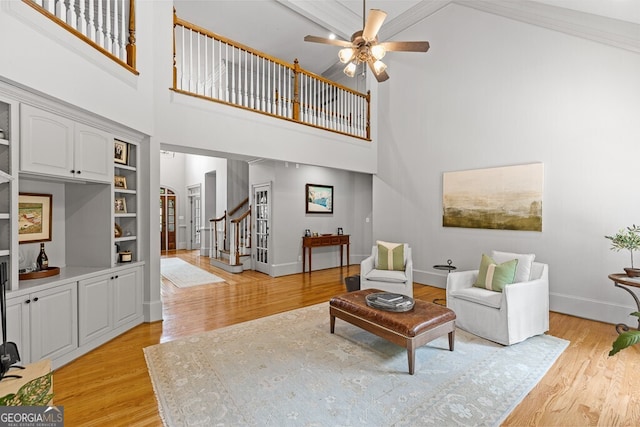2332 Autumn Maple Dr, Braselton, GA 30517 - living area with a towering ceiling, stairs, light wood-type flooring, arched walkways, and baseboards