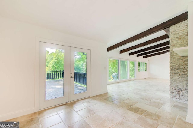 spare room with french doors, stone tile floors, beam ceiling, and baseboards