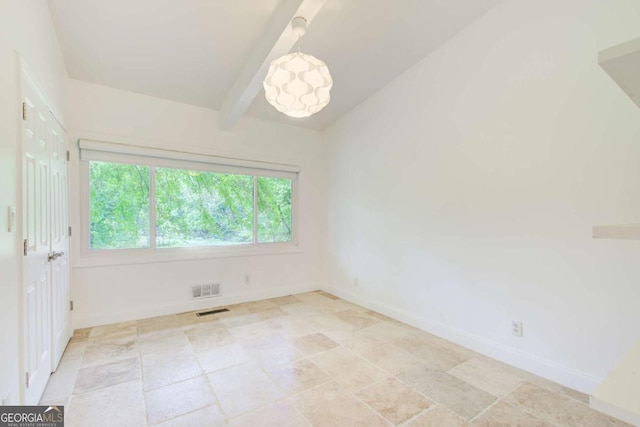 unfurnished room with baseboards, beamed ceiling, and light stone finish floors