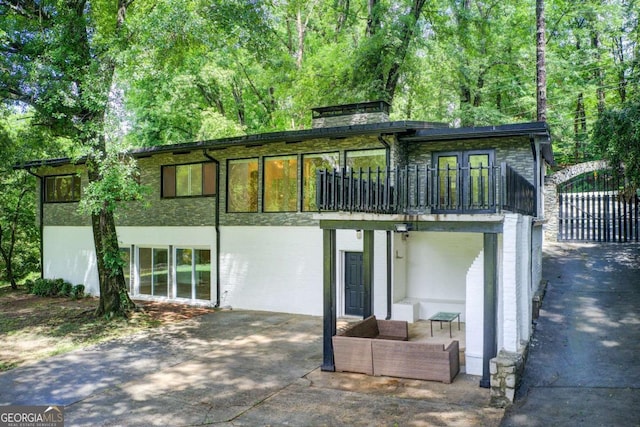 rear view of property with a patio area and a balcony