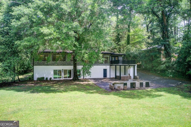 back of house featuring a lawn and a patio