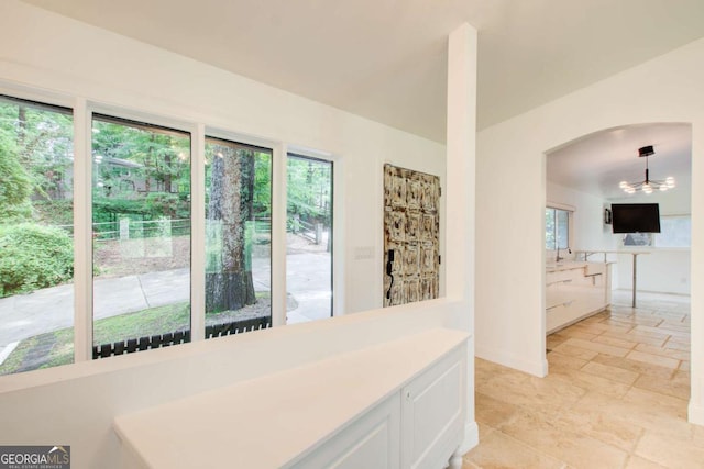 kitchen with plenty of natural light, white cabinets, stone tile flooring, and light countertops