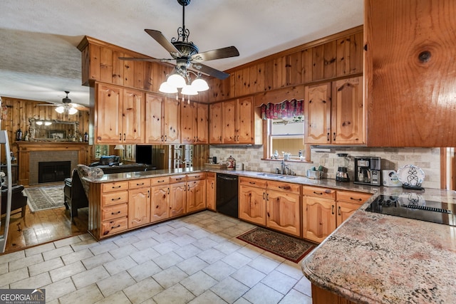 kitchen with a ceiling fan, black appliances, a sink, tasteful backsplash, and a peninsula