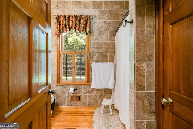 bathroom with wood finished floors and a shower with shower curtain