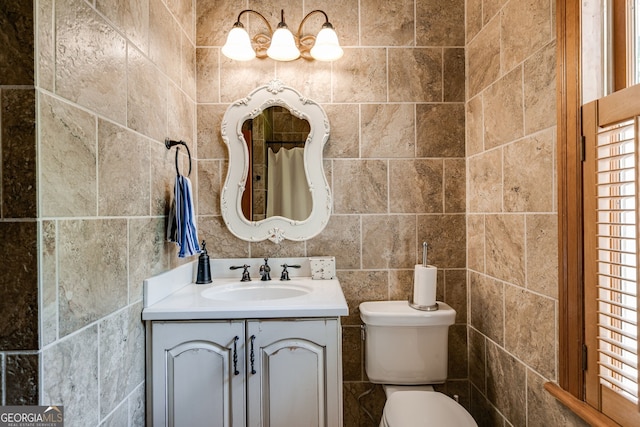 bathroom featuring tile walls, toilet, and vanity