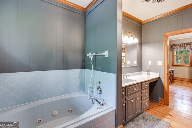 full bathroom featuring wood finished floors, a tub with jets, vanity, and crown molding