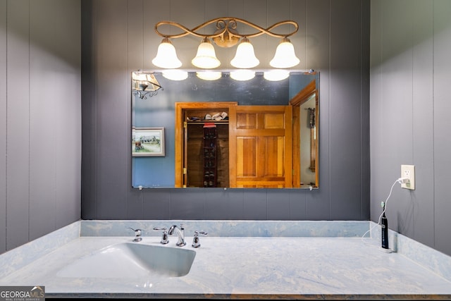 bathroom with vanity and a decorative wall
