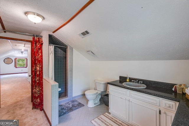 bathroom with vaulted ceiling, a stall shower, toilet, vanity, and a textured ceiling