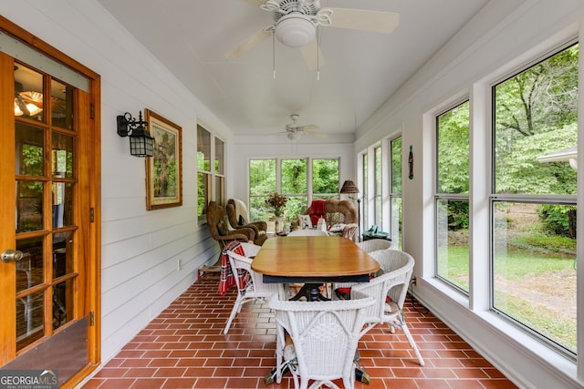 sunroom featuring plenty of natural light and wooden walls
