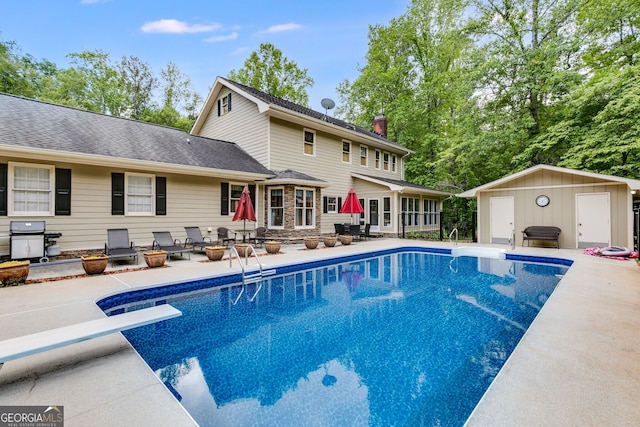 outdoor pool featuring a patio, a diving board, an outdoor structure, and a grill