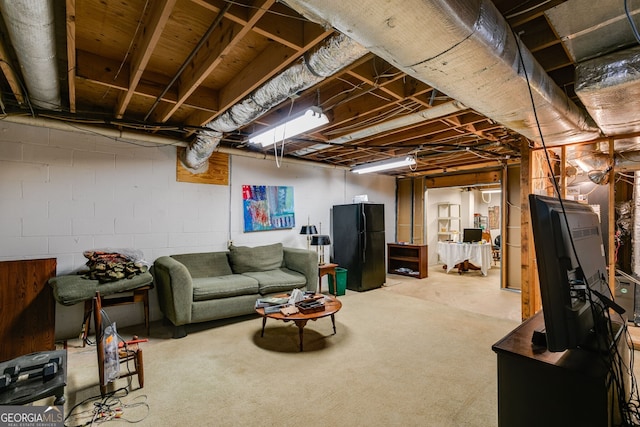 unfinished basement featuring freestanding refrigerator