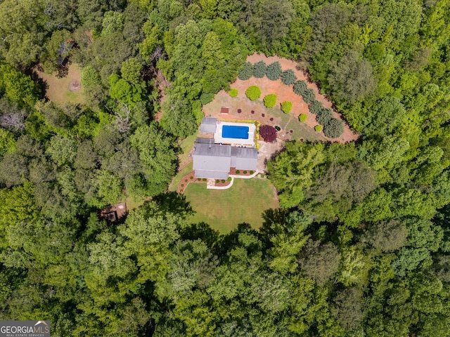 view of subject property with a heavily wooded area