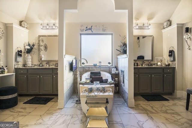 full bath featuring marble look tile flooring and two vanities