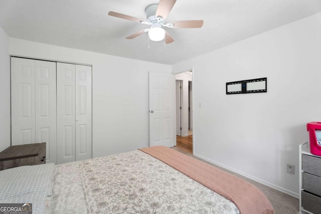 carpeted bedroom featuring a closet, baseboards, and ceiling fan